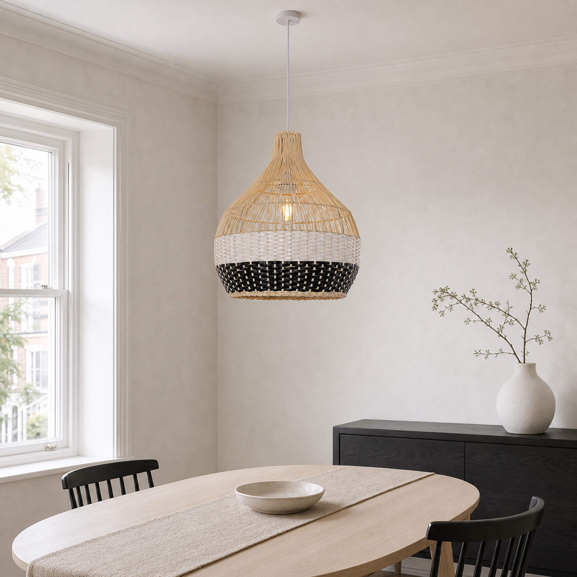 black white rattan pendant light above a bright dining table