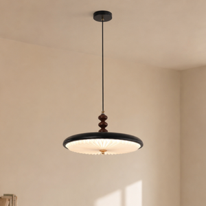 black pleated pendant light with black pleated shade and warm LED glow