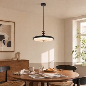 black pleated pendant light above a round dining table