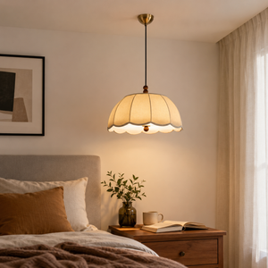 yellow fabric pendant light above a bedside table in a warm bedroom