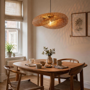 bamboo pendant light over a wooden dining table by sash windows