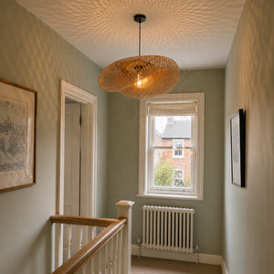 bamboo ceiling light casting patterned shadows in a stair landing