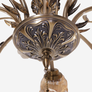 antique bronze chandelier with amber flower shades glowing above a dining table