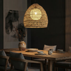 Rattan pendant light with inner sphere above a dark restaurant table