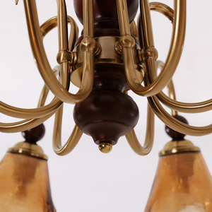 8-light walnut chandelier with amber cut glass shades glowing above a dining table