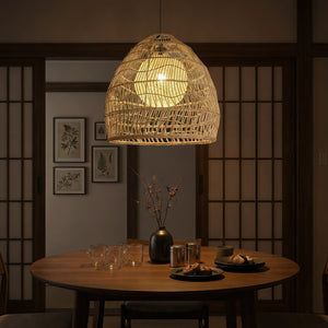 Rattan pendant light with inner sphere above a moody dining table