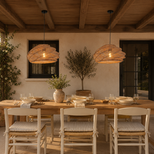 two warm rattan pendant lights above a rustic dining table with wood ceiling