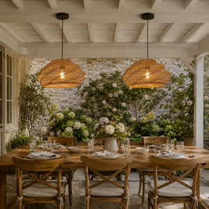 two spiral rattan pendant lights over a garden dining table with flowers