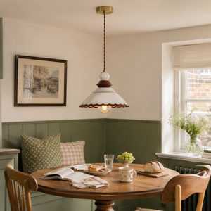 brown ceramic lace pendant light above a dining table with green bench seating