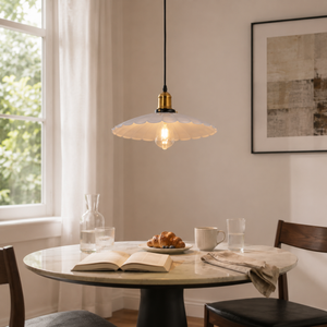 white iron pendant light above a round dining table by a window