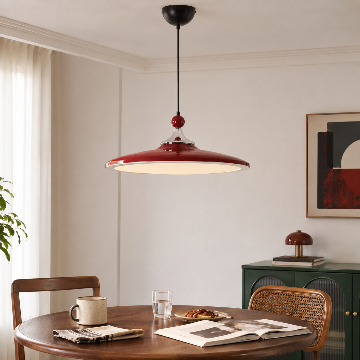 red iron pendant light above a dining table with woven chairs