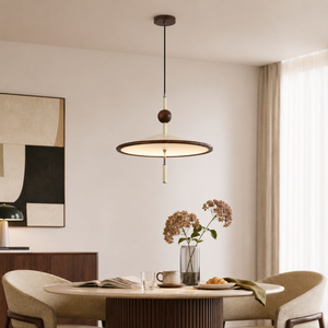 beige iron pendant light above a bright dining table