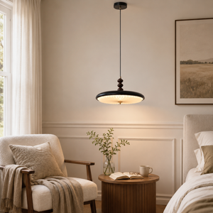 black pleated pendant light beside a lounge chair and small table