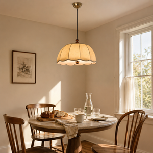 yellow fabric pendant light above a round dining table by a window