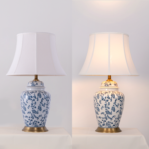 blue floral ceramic table lamp shown unlit and glowing with warm light