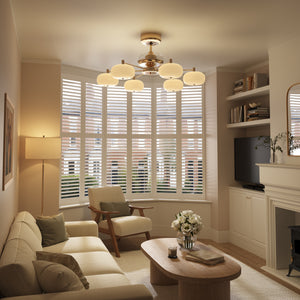 Copper acrylic ceiling fan light with warm glow in a cosy living room lounge