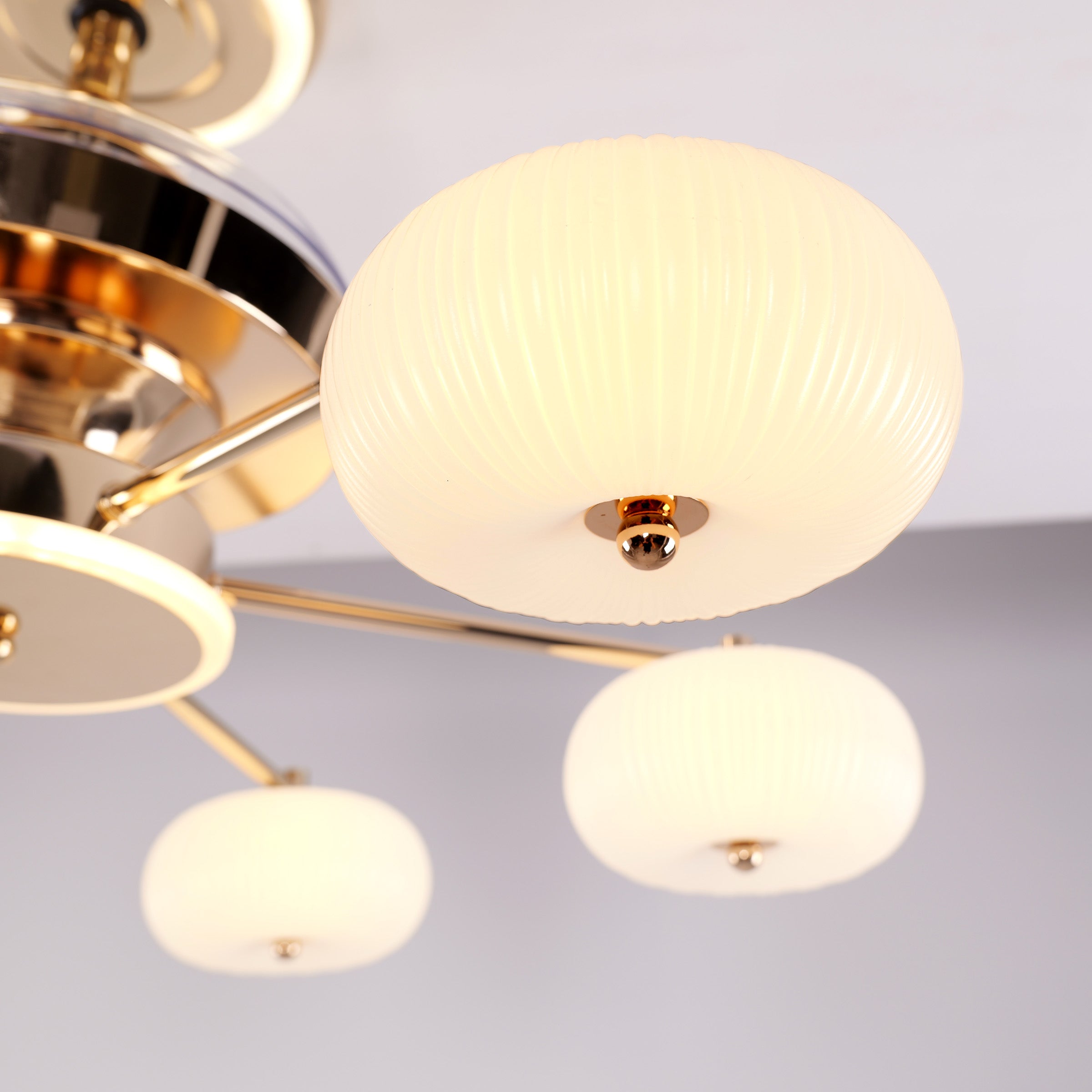 Acrylic globe shades glowing on a copper ceiling fan light close-up