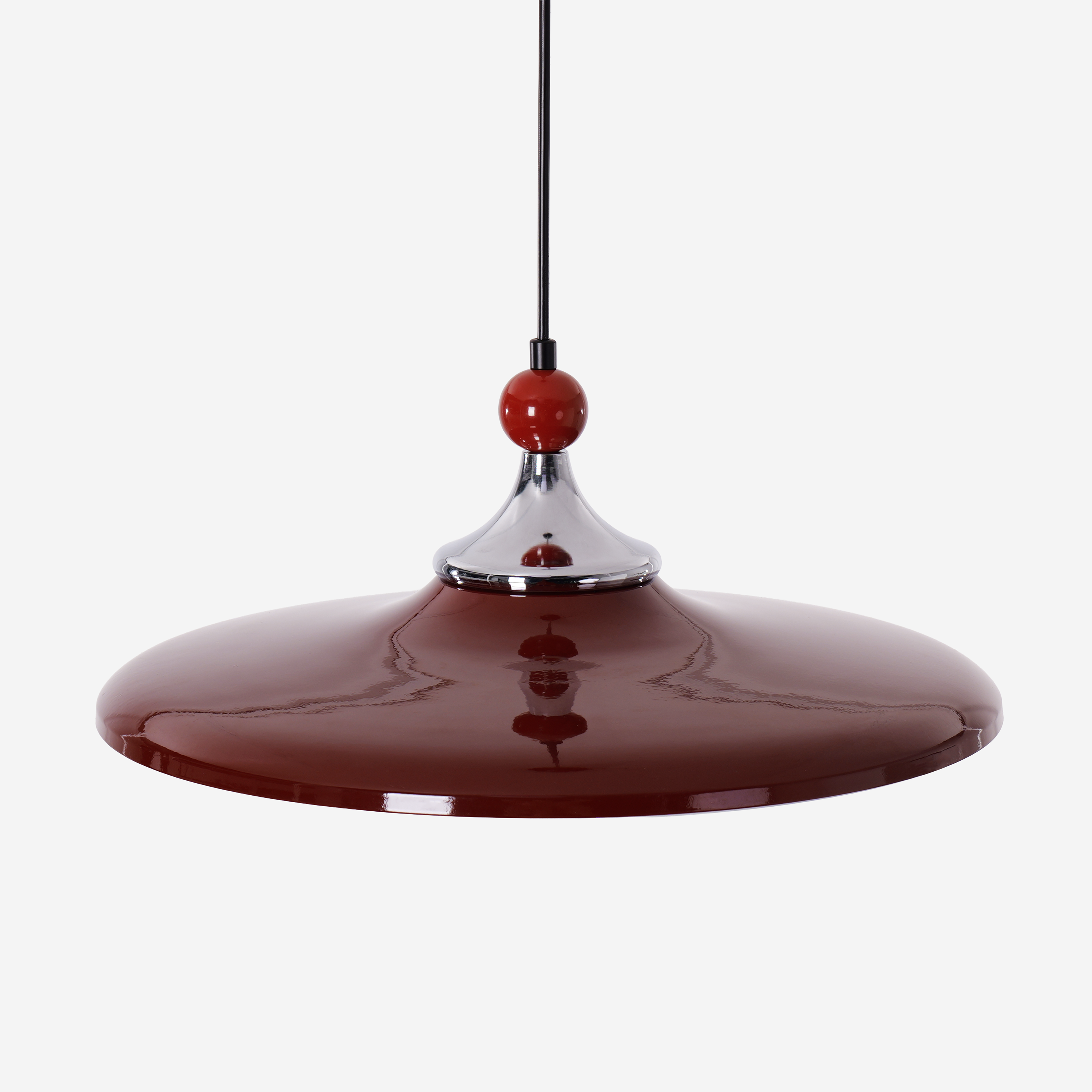 red iron pendant light hung above a dining table