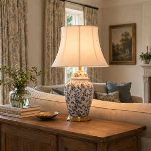 blue floral ceramic table lamp on a wooden console in a classic sitting room
