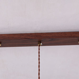 3-light walnut resin mini pendant adding warm light to a dining space