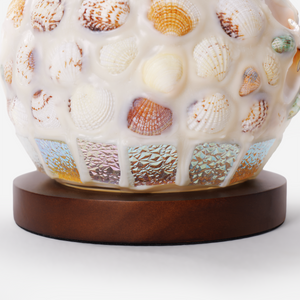 seashell mosaic table lamp adding warm light to a bedroom