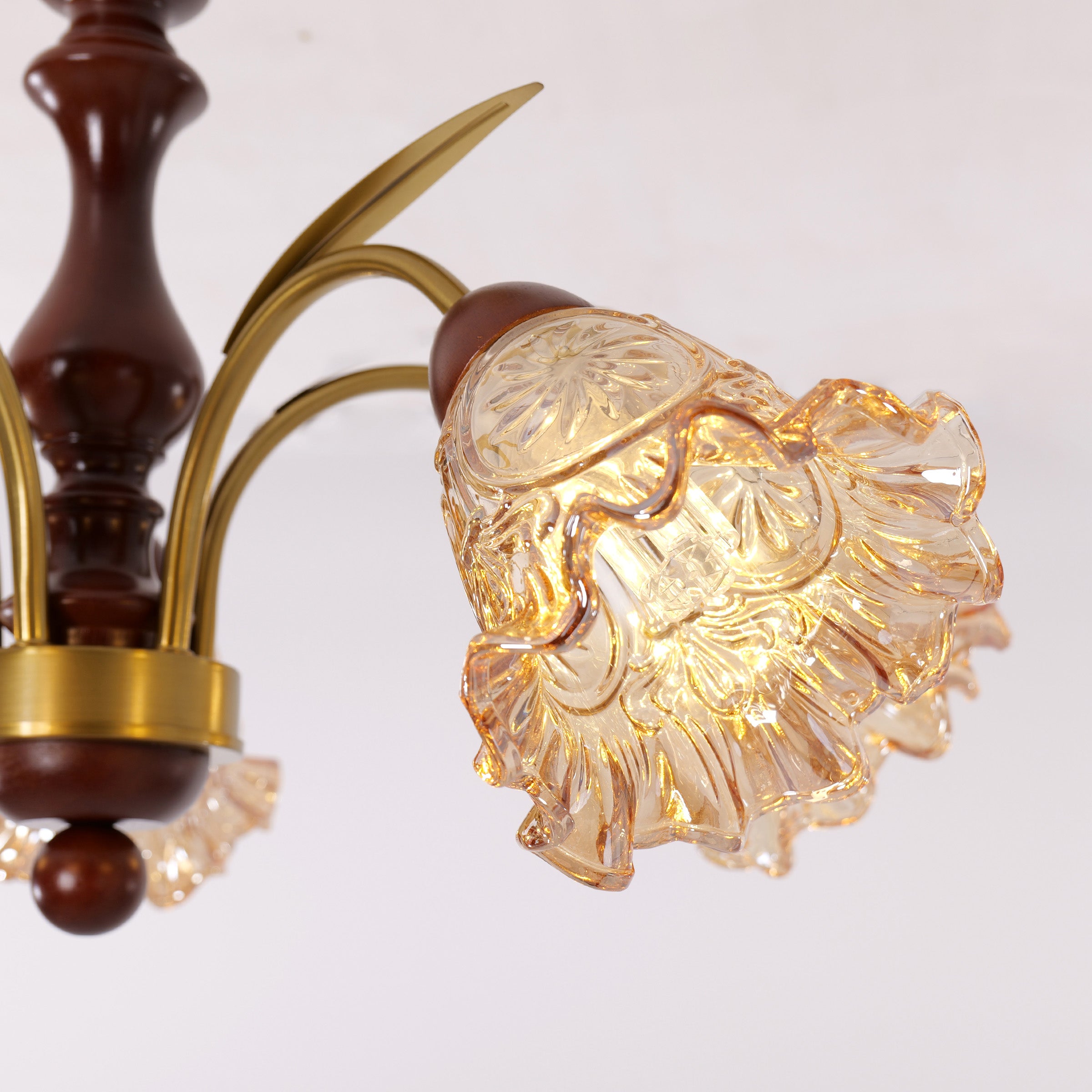 5-light copper chandelier with flower glass shades adding soft light to a bedroom