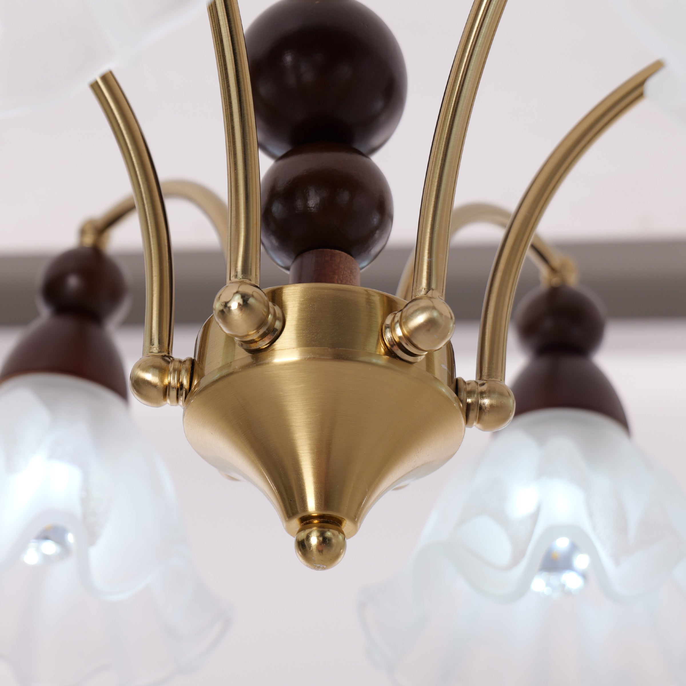 6-light chandelier with white glass shades glowing above a dining table