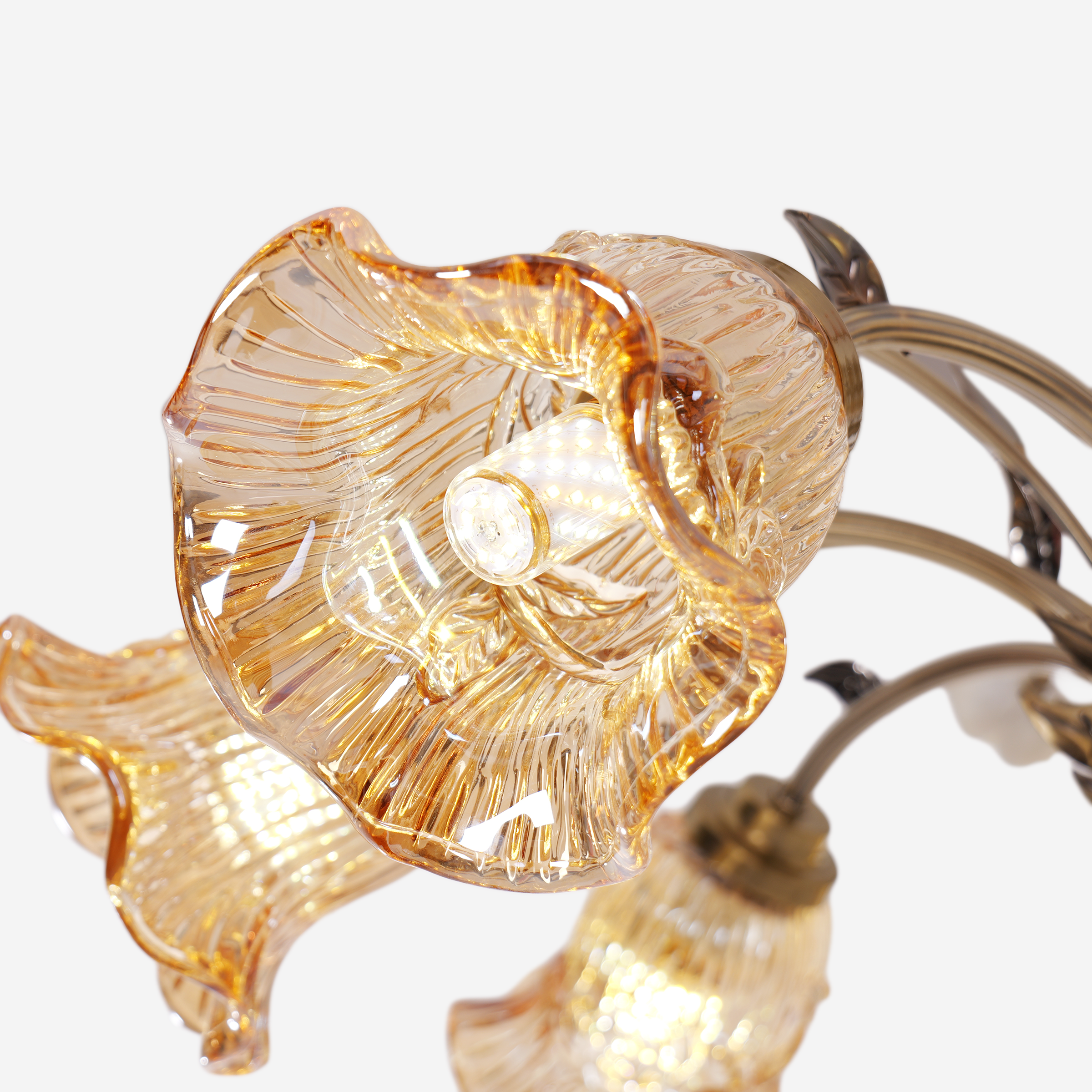 antique bronze chandelier with amber flower shades adding soft light to a bedroom
