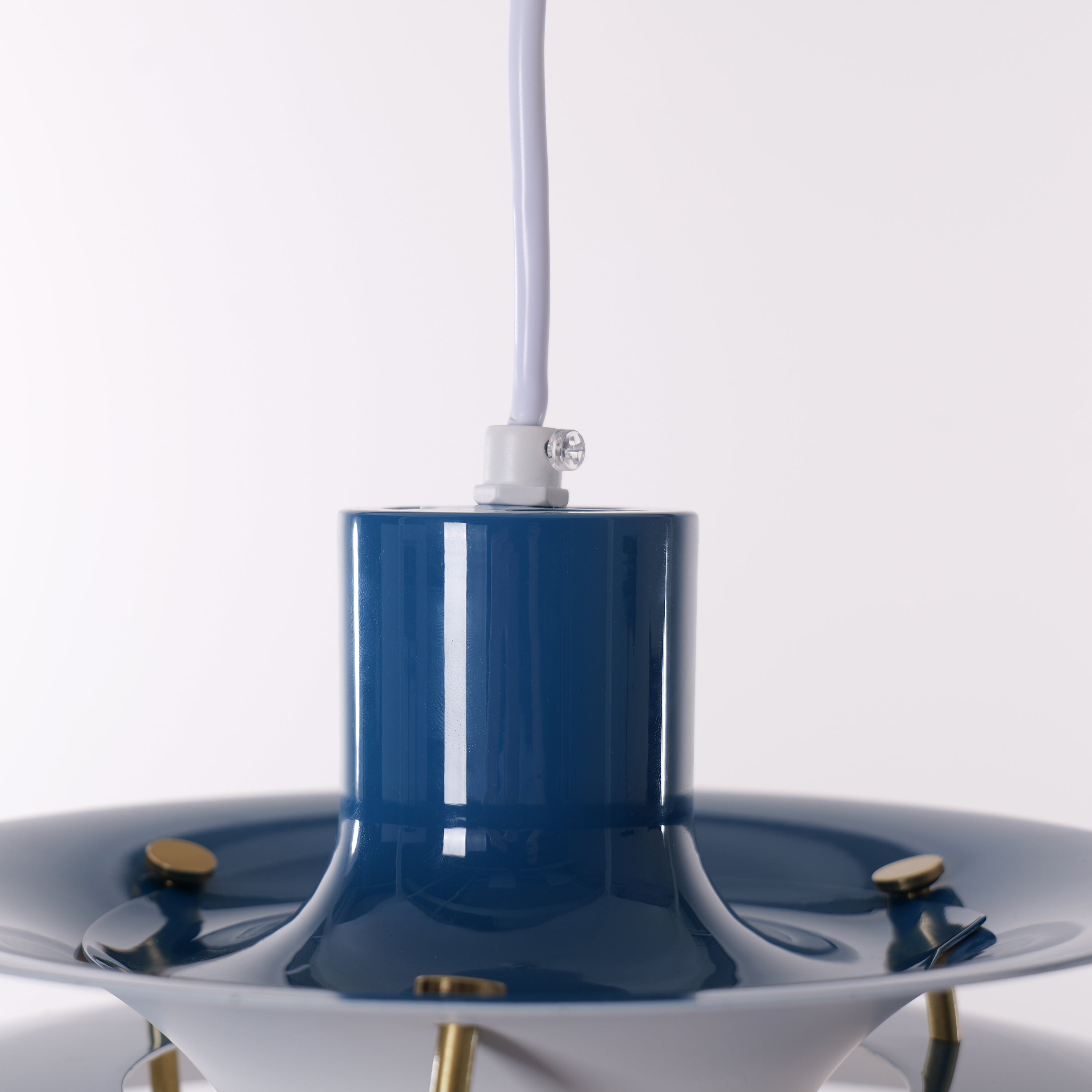 blue layered minimalist pendant light adding warm light to a dining space