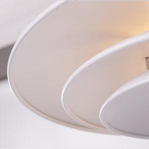 white layered minimalist pendant light hung above a dining table