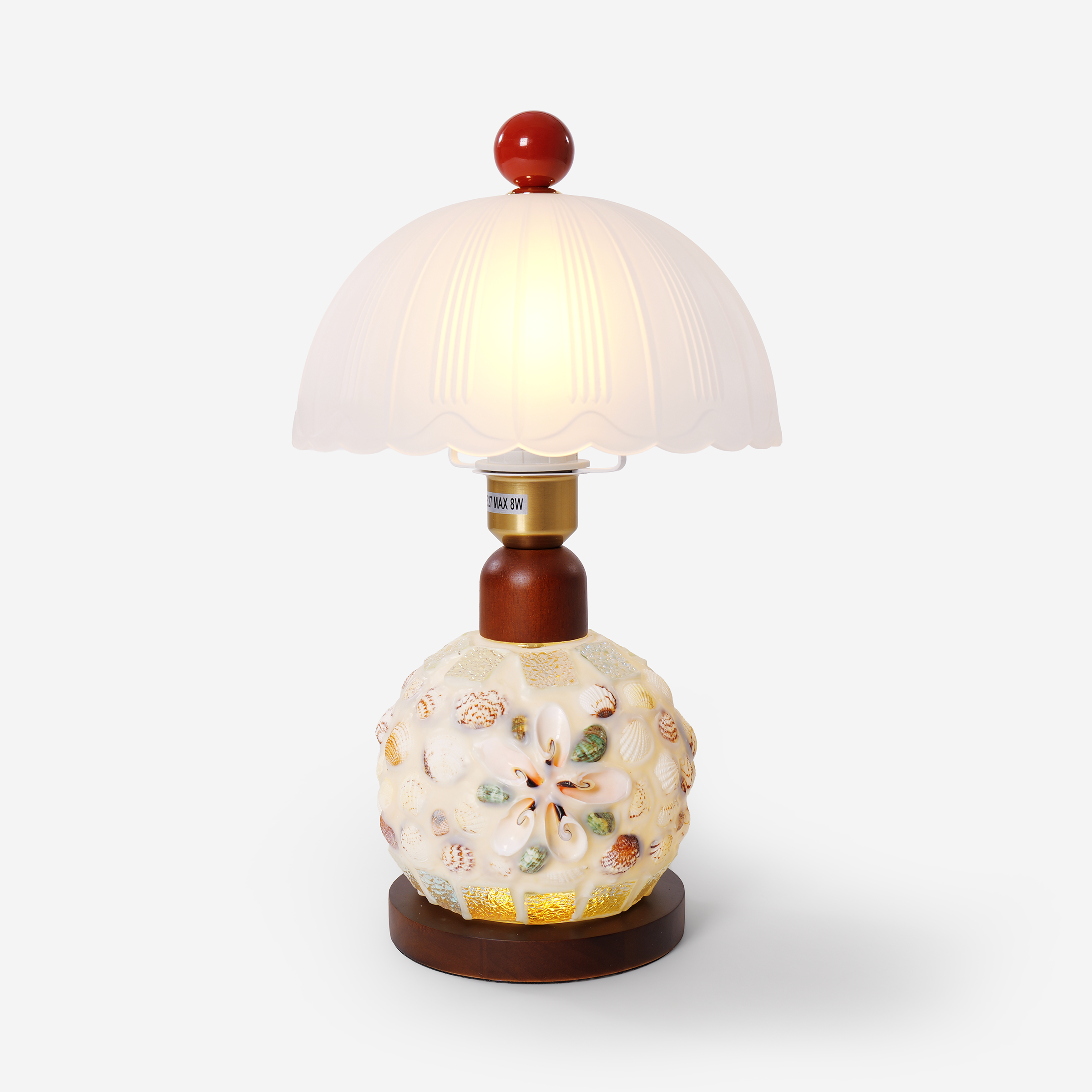 seashell mosaic table lamp on a desk with soft ambient light