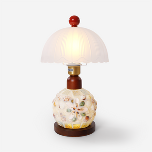 seashell mosaic table lamp on a desk with soft ambient light
