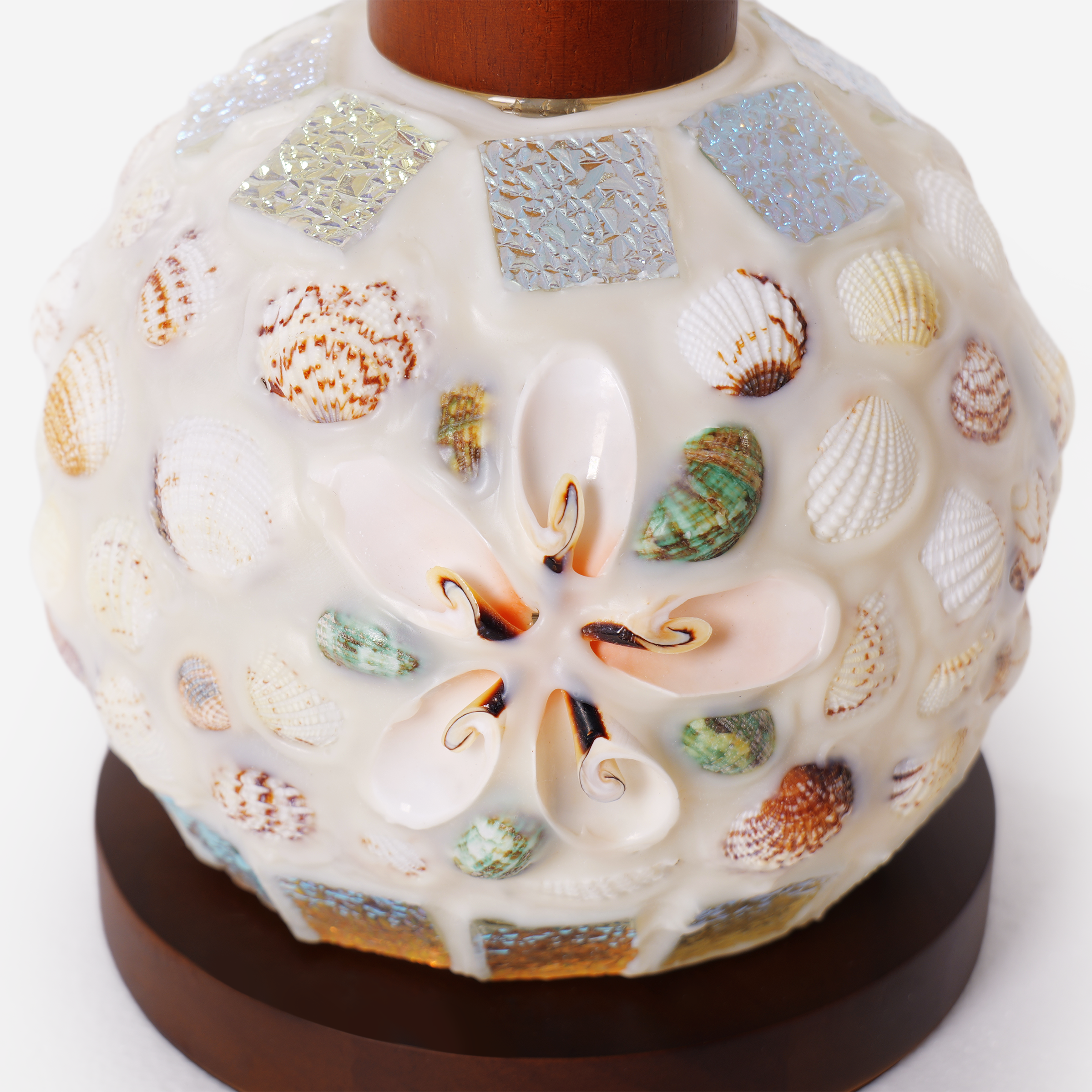 seashell mosaic table lamp glowing on a bedside table