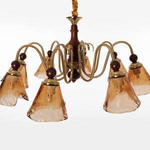 8-light walnut chandelier with amber cut glass shades adding soft light to a bedroom
