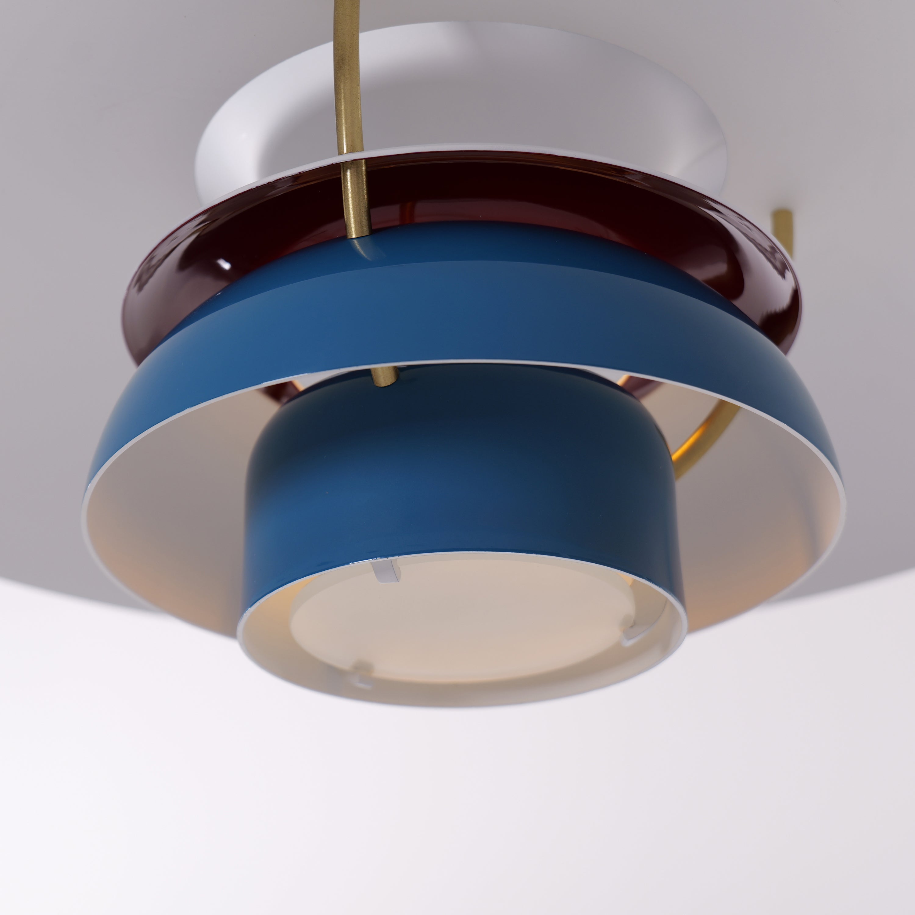blue layered minimalist pendant light hung above a dining table