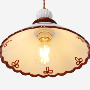 brown ceramic lace pendant light hung above a dining table