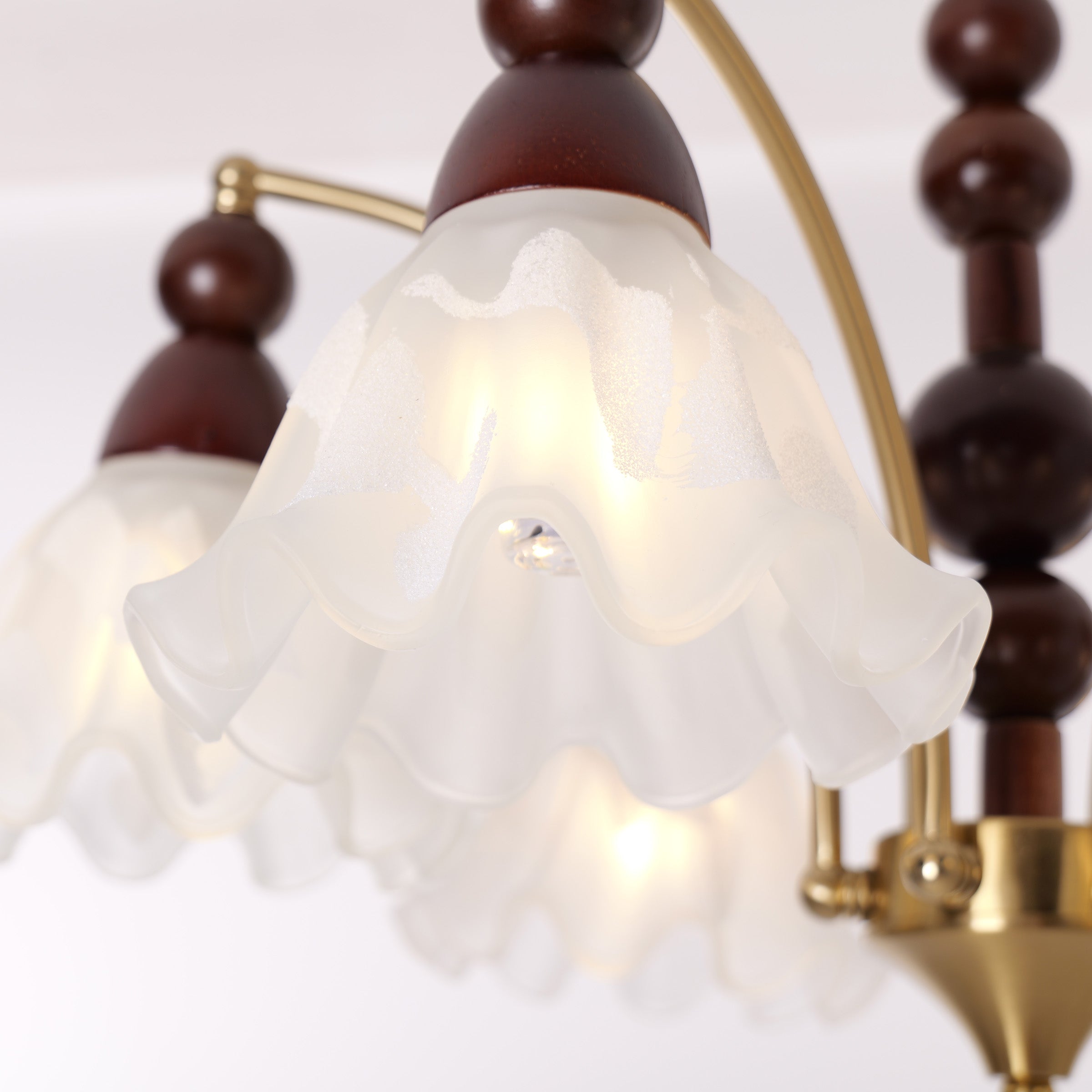 6-light chandelier with white glass shades adding soft light to a bedroom
