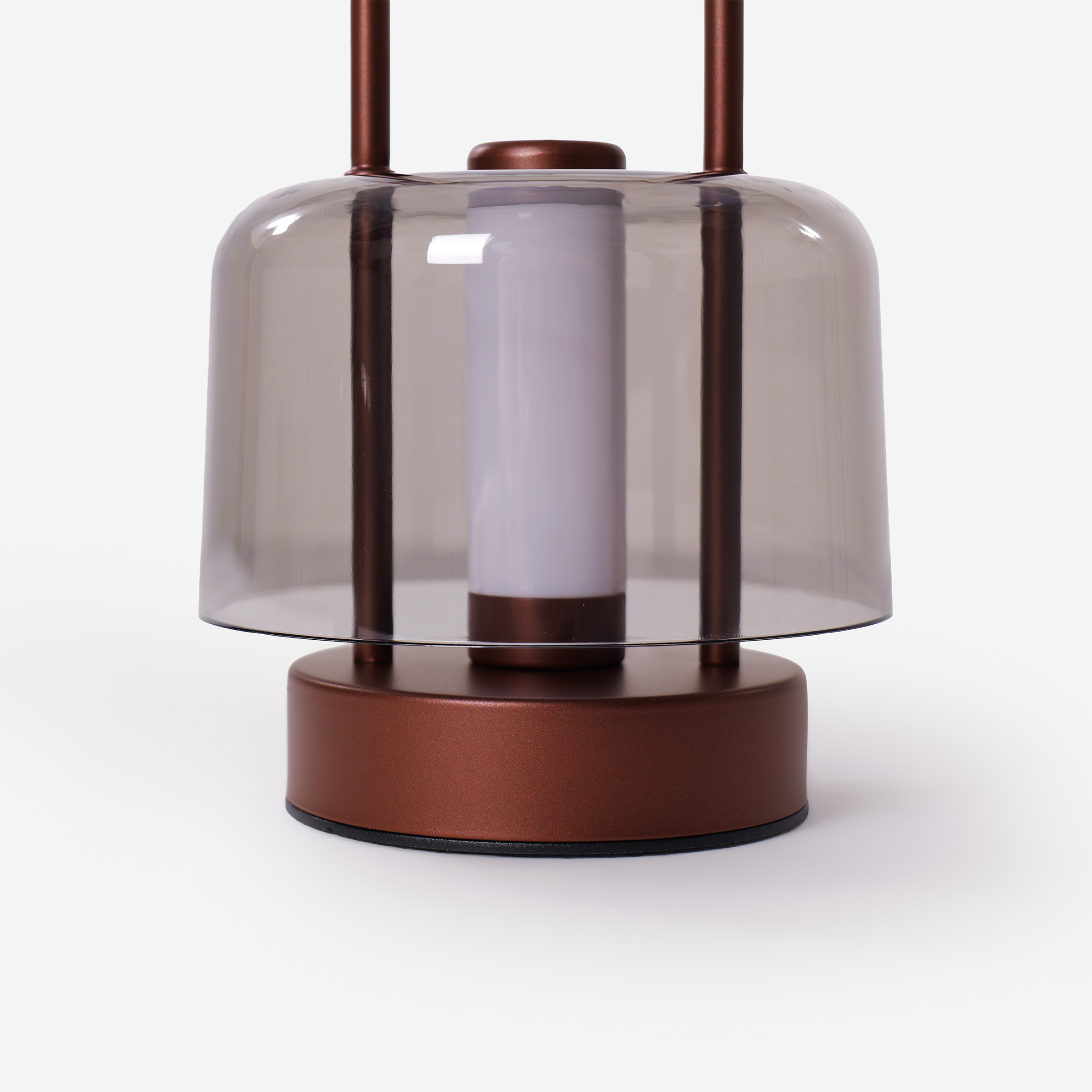 portable lantern-style ambient table lamp glowing on a bedside table
