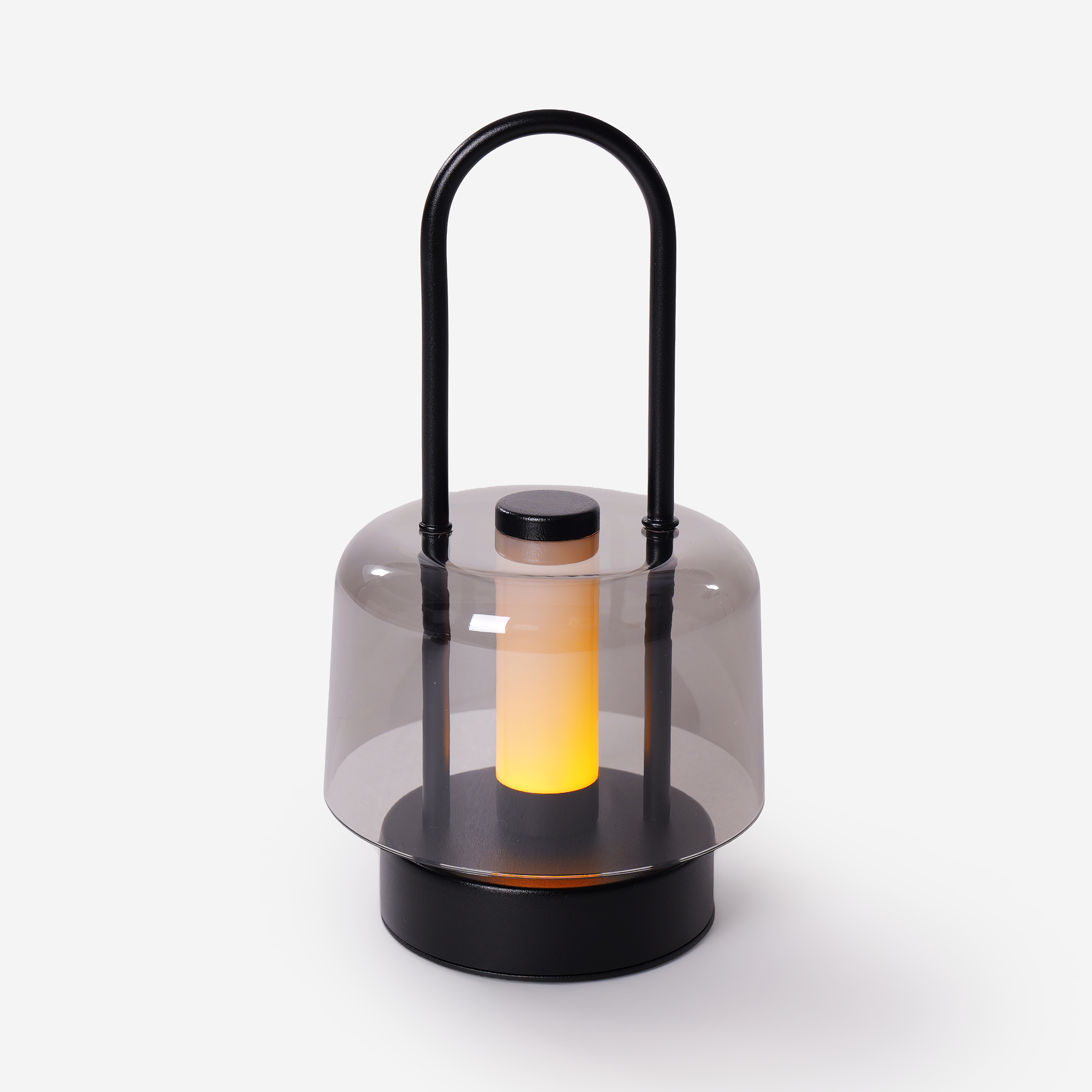 portable lantern-style ambient table lamp glowing on a bedside table