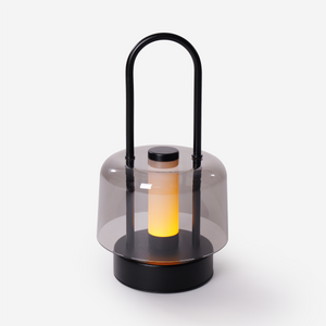 portable lantern-style ambient table lamp glowing on a bedside table