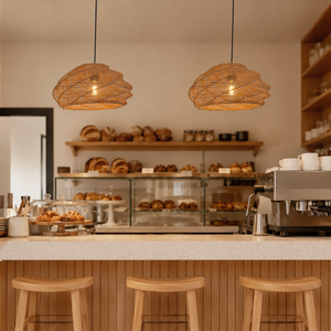 two woven rattan pendant lights above a cafe counter with stools