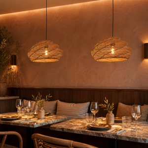 spiral rattan pendant lights above an intimate restaurant table with amber wall light