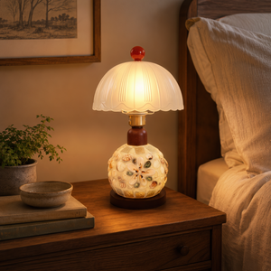 seashell mosaic table lamp glowing on a bedside table