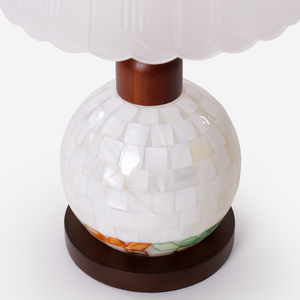 mother-of-pearl mosaic table lamp glowing on a bedside table