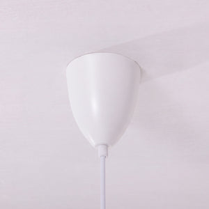 white layered minimalist pendant light adding warm light to a dining space