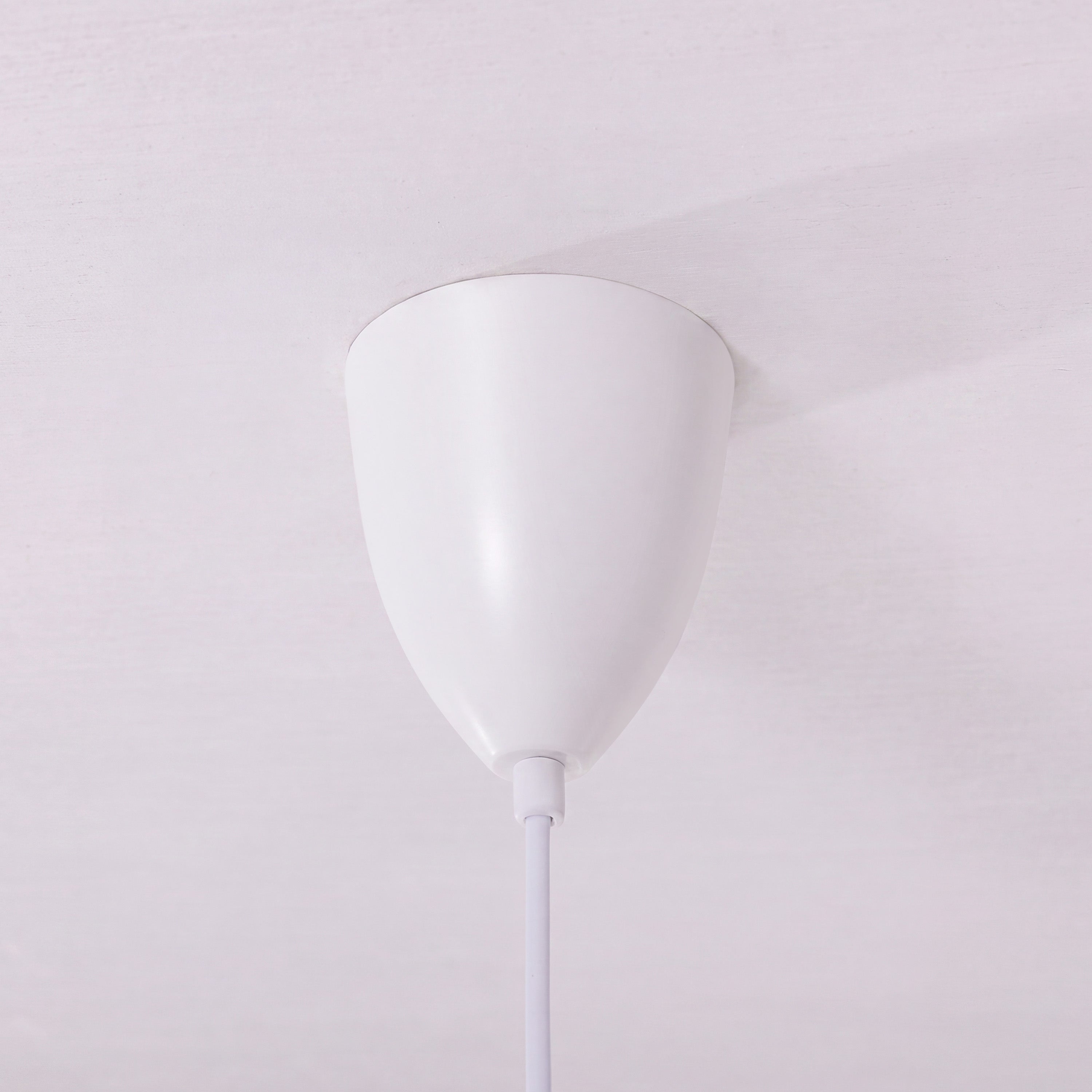 white layered minimalist pendant light adding warm light to a dining space
