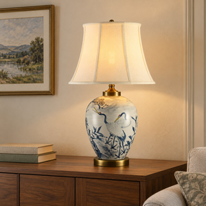 Blue and white crane lamp on a wooden sideboard beside a sofa