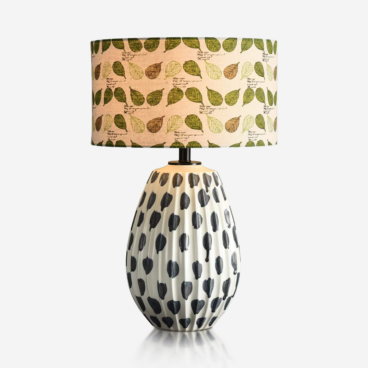 Black and white spotted ceramic lamp with green leaf-print shade