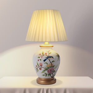 White Chinoiserie Hand-Painted Ceramic Table Lamp table lamp shown lit with warm